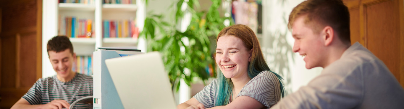 teenagers looking at lapotop and smiling